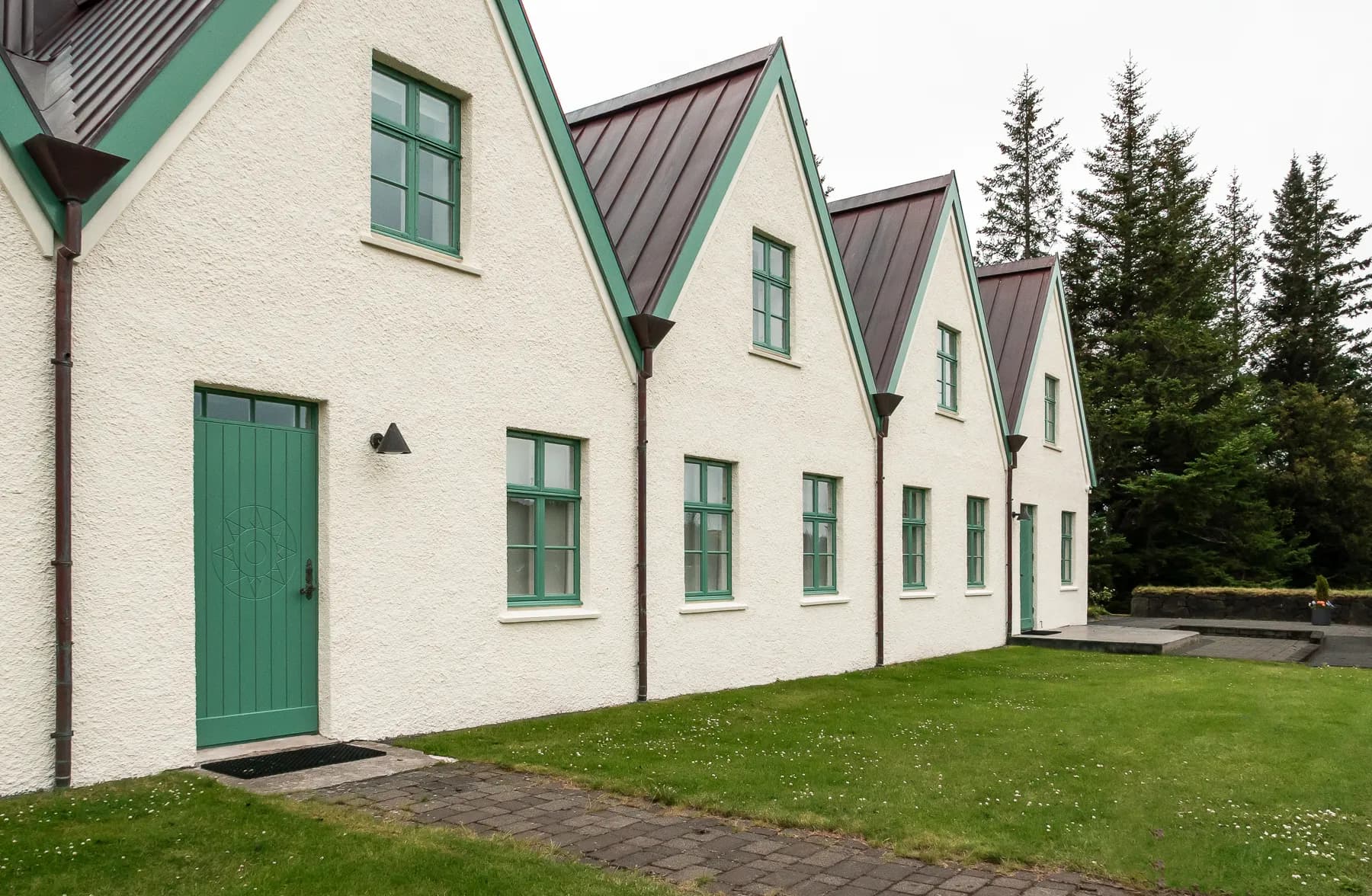 White housing with green trim set in the grassy landscape of Þingvellir National Park, Iceland.