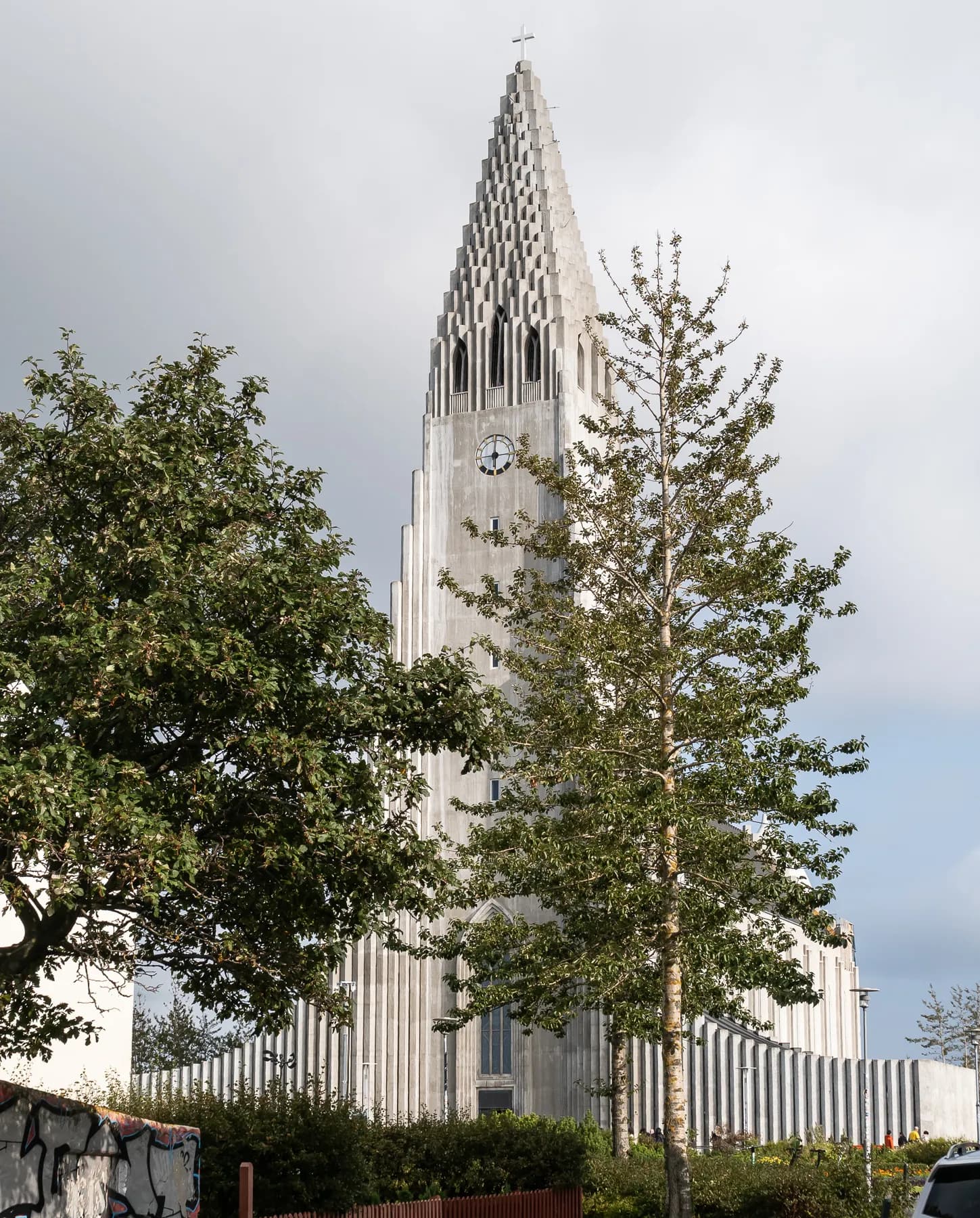 Tall modern church spire rising behind trees in Reykjavik, Iceland.
